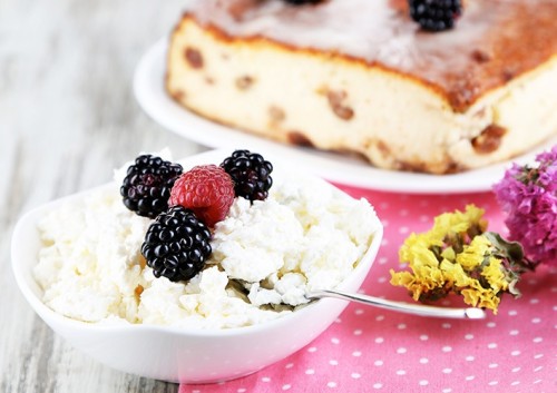 Cheese casserole with raisins on plate on napkin on wooden table close-up