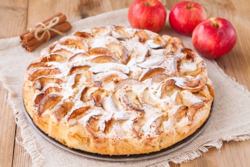 apple pie on a wooden background with cinnamon